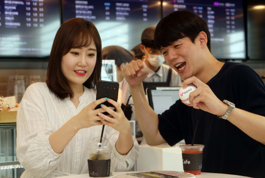 LG유플러스 모델이 프로야구 전용 앱 'U+프로야구'로 응원하며 야구 중계를 즐기고 있다. LG유플러스 제공